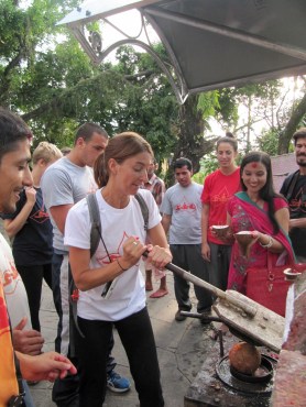 Utilizing the coconut-chopping station at a temple in Pokhara, Nepal.